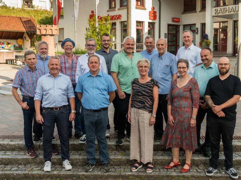 Die Brigachtaler Gemeinderäte stehen gemeinsam auf dem Vorplatz des Rathauses und lachen in die Kamera 