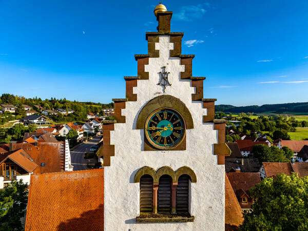 Luftaufnahme der Turmspitze der Kirche St. Martin bei blauem Himmel und Sonne