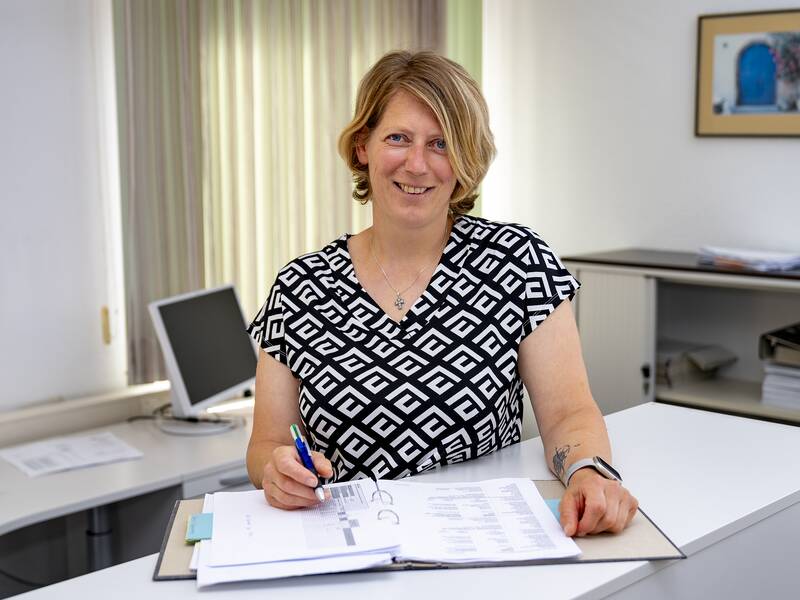 Sandra Dold steht in einem Büro und lächelt in die Kamera