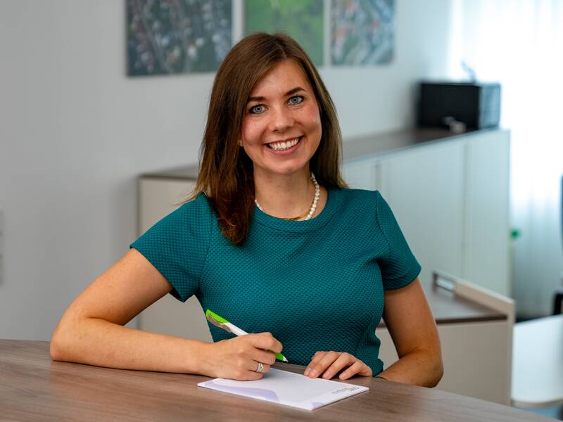 Tanja Traichel steht in einem Büro und lächelt in die Kamera